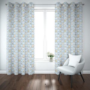 Puede incluir: Cortinas estampadas de color azul claro con un diseño repetitivo de marcos ovalados que contienen ilustraciones. Las cortinas cuelgan frente a una ventana, con una silla blanca y una pequeña planta en maceta visibles.