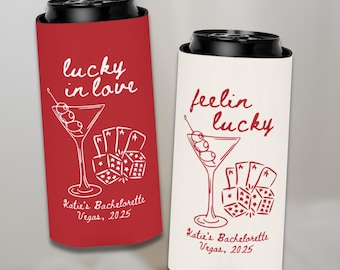 May include: Two red and white can coolers with a martini glass and dice design. The text on the coolers reads "lucky in love" and "feelin lucky". The text also includes "Katie's Bachelorette Vegas, 2025".