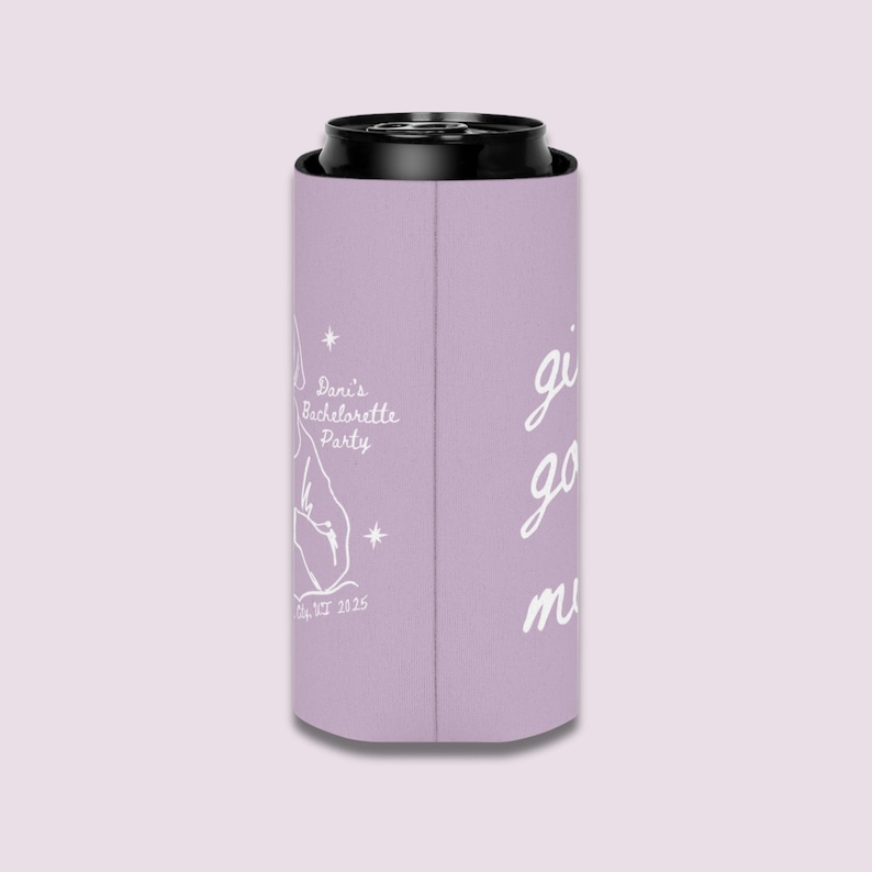 May include: A lavender can cooler with black trim. The cooler has white text that reads "Dani's Bachelorette Party" with a graphic and "Est. 2025". The words "girls go must" are also written on the cooler.
