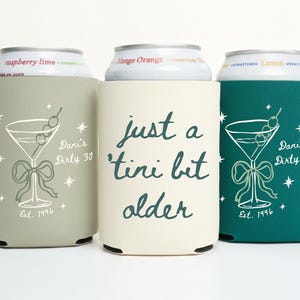 May include: Three beverage can coolers in sage green, cream, and teal. Each features a martini glass design with a bow, text that reads "Dani's Dirty 30" and "Est. 1996". The cream cooler has the text "just a 'tini bit older".