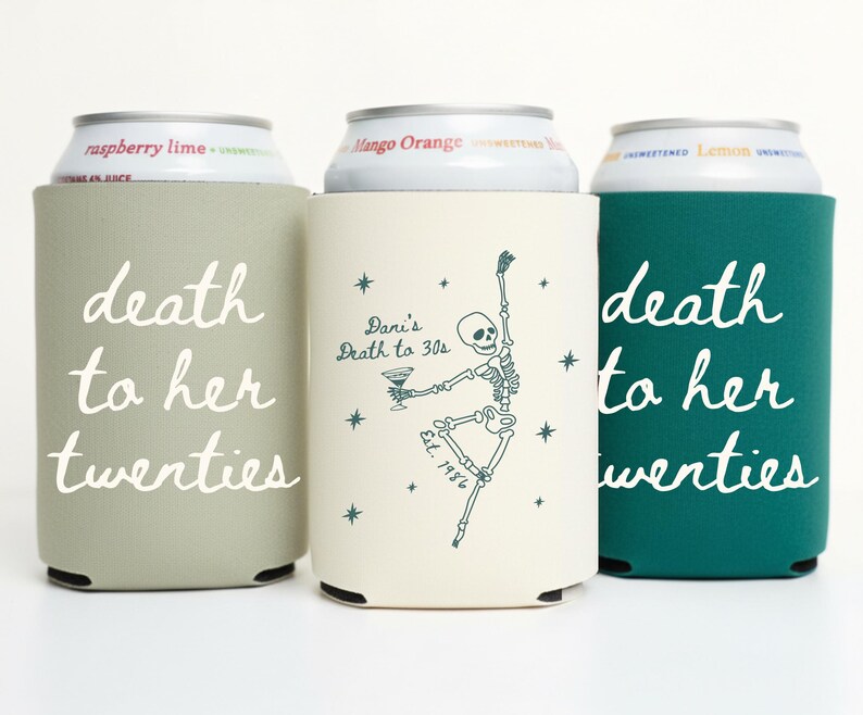 May include: Three beverage can coolers in sage green, cream, and teal. The sage green and teal coolers have the text "death to her twenties" in white script. The cream cooler features a dancing skeleton illustration and the text "Dani's Death to 30s".