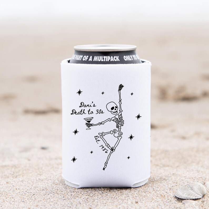 May include: White can cooler with a black skeleton illustration holding a martini. The text "Dani's Death to 30s" and "Est. 1986" are also printed on the cooler. Black star accents surround the skeleton.