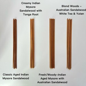 May include: Four bundles of incense sticks are displayed against a white background. The bundles are labeled with text indicating the type of sandalwood and other ingredients. The incense sticks are various shades of brown.