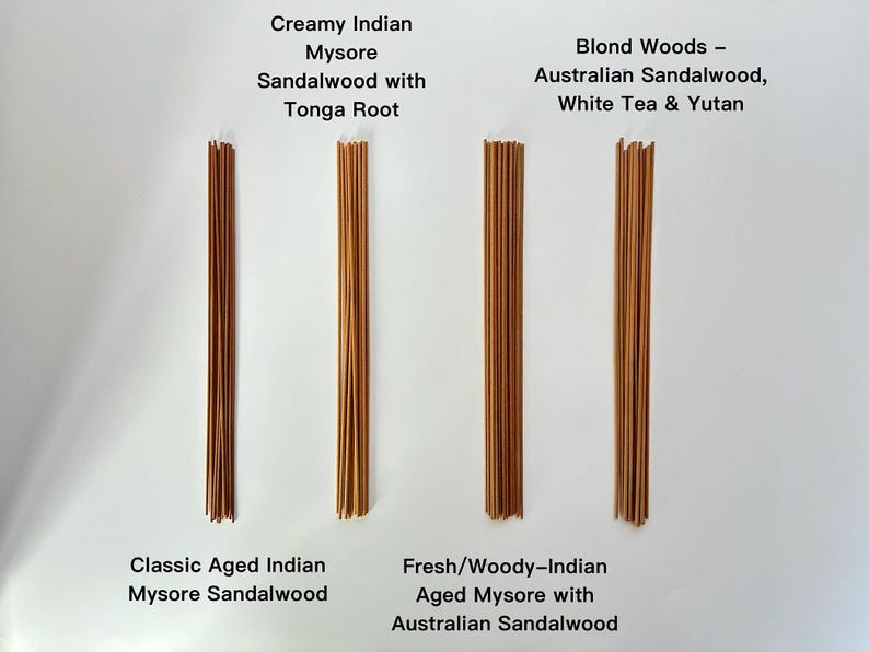 May include: Four bundles of incense sticks are displayed against a white background. The bundles are labeled with text indicating the type of sandalwood and other ingredients. The incense sticks are various shades of brown.