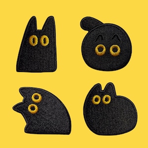 May include: Four black cat-shaped embroidered patches with yellow eyes on a yellow background. Each patch features a different cat design, including a tall, thin cat, a round cat, and two cats with curved shapes.