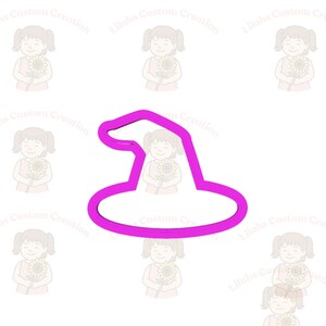 Puede incluir: Un cortador de galletas con forma de sombrero de bruja rosa brillante. El cortador es un contorno sólido de un sombrero de bruja clásico, con un ala ancha y una parte superior puntiaguda. El fondo presenta un patrón repetido de una niña sosteniendo un girasol.