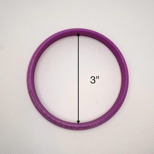May include: A purple silicone ring with a diameter of 3 inches.