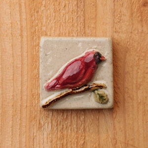 Handmade 2x2 ceramic cardinal tile facing right comes with a hanger on the back