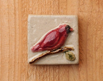 Handmade 2x2 ceramic cardinal tile facing right comes with a hanger on the back