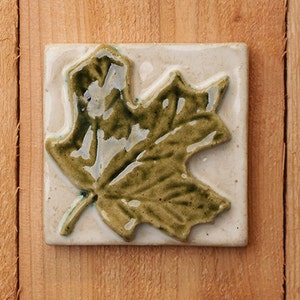 Handmade 4x4 ceramic relief Maple Leaf tile comes with a hanger on the back, suitable for tile installation