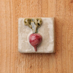 Handmade 2x2 ceramic radish tile comes with a hanger on the back or ready for a tile installation