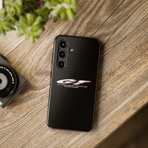 May include: A black phone case with a white and red logo that says "GT All Japan Grand Touring Car Championship".