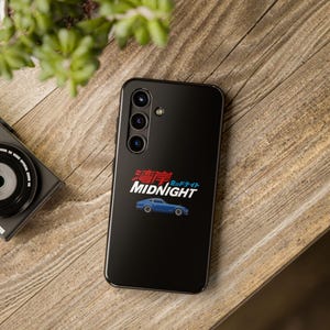 May include: A black phone case with a blue and red graphic of a car and the text "MIDNIGHT" in Japanese and English.