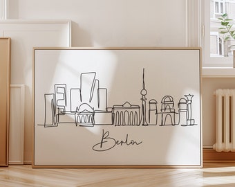 Puede incluir: Un dibujo en blanco y negro de la línea del horizonte de Berlín, que incluye la Puerta de Brandeburgo, el edificio del Reichstag y la Torre de Televisión de Berlín. El dibujo está sobre un fondo blanco con la palabra "Berlín" escrita en cursiva debajo del horizonte.
