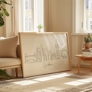 May include: A framed black and white line drawing of the London skyline, including Big Ben, the London Eye, and other iconic landmarks. The drawing is on a beige background and the word "London" is written in cursive at the bottom.