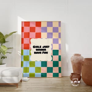 May include: A digital art print with a checkered pattern in pink, red, green, blue, and purple. The print features a white speech bubble with the text "Girls Just Wanna Have Fun" in black.