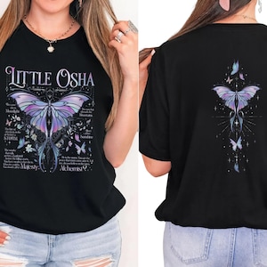 A woman wearing a black t-shirt with a butterfly design and text on it.
