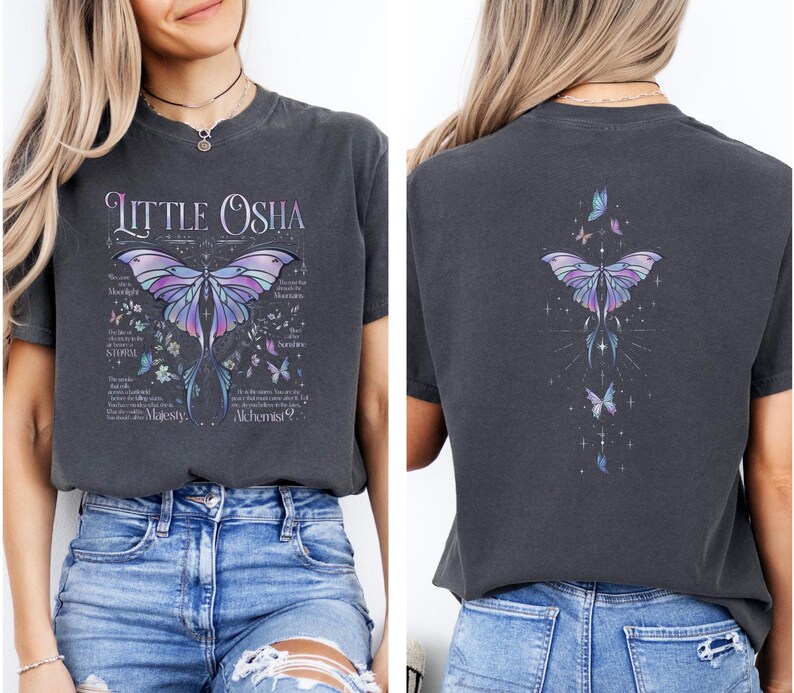 A woman wearing a gray t-shirt with a graphic design featuring butterflies and text.
