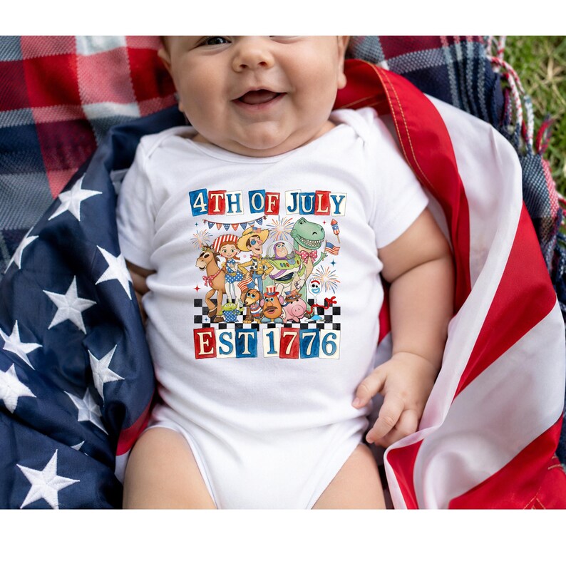 A baby wearing a white onesie with a patriotic design and text related to the 4th of July holiday.