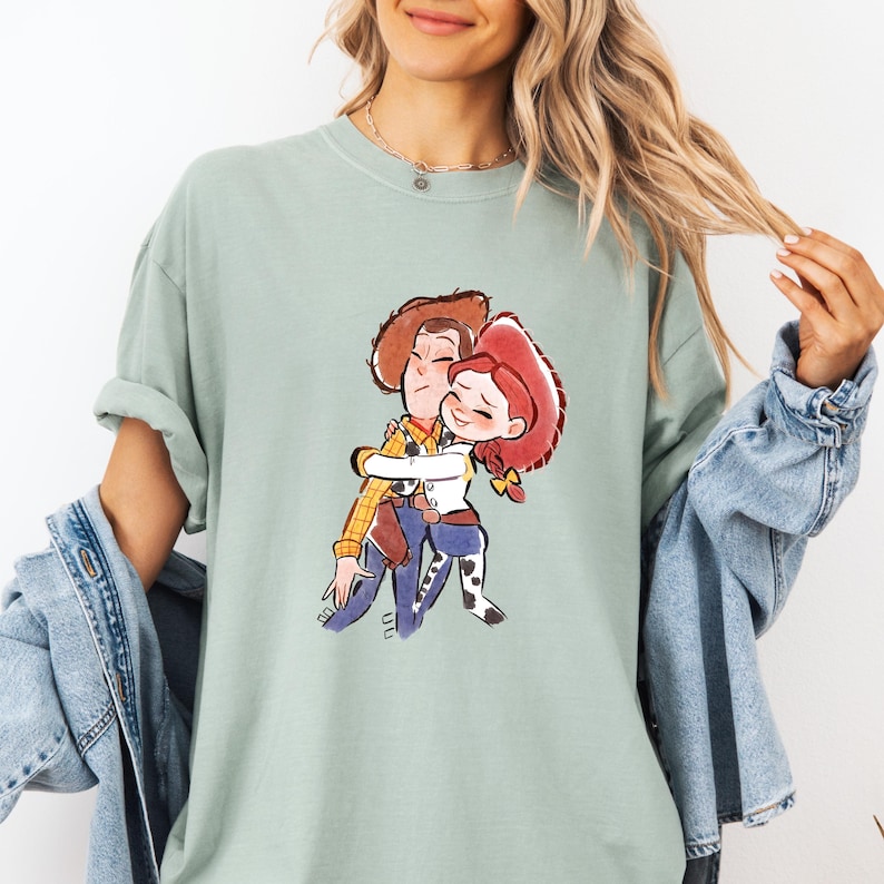 a woman wearing a t - shirt with a picture of a boy hugging a girl