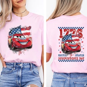 a woman wearing a pink shirt with cars printed on it