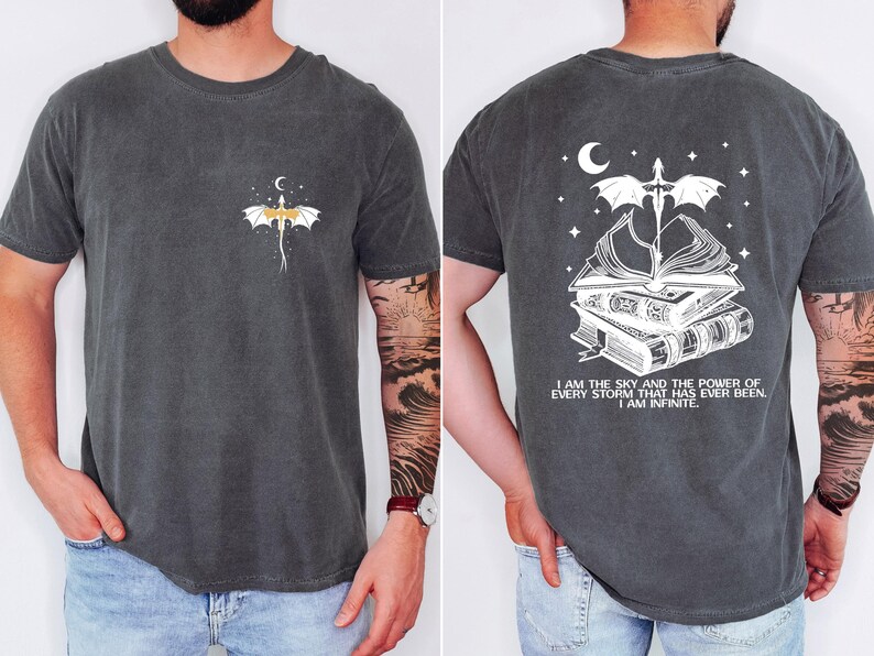 a man wearing a gray t-shirt with a graphic design on the front and back. The design features a dragon and a crescent moon, along with the text "I am the sky and the power of every storm that has ever been, I am infinite".