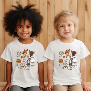 Two young children wearing white t-shirts with various cartoon animal characters printed on them.