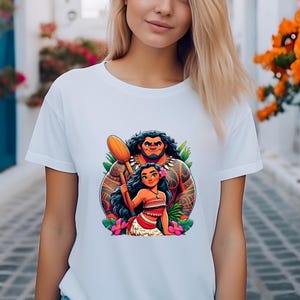 May include: White t-shirt with a vibrant cartoon illustration of two characters. The characters are a muscular man with tattoos and a woman with long black hair, a flower, and a red and white outfit. The man is holding a wooden oar.
