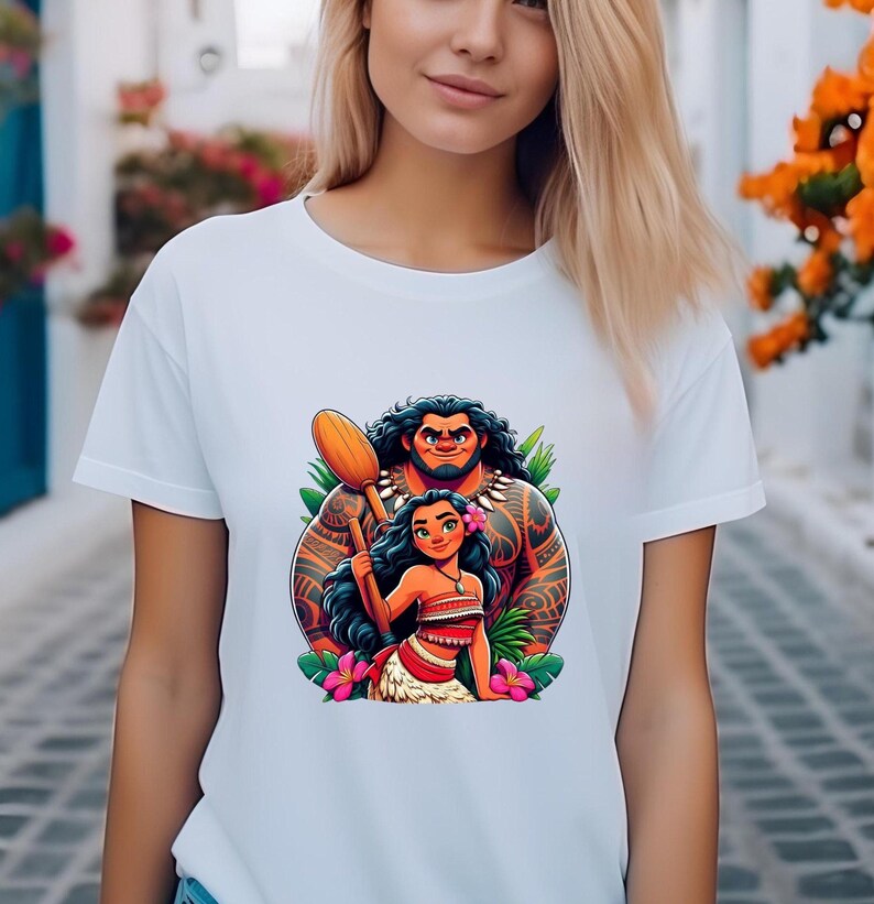 May include: White t-shirt with a vibrant cartoon illustration of two characters. The characters are a muscular man with tattoos and a woman with long black hair, a flower, and a red and white outfit. The man is holding a wooden oar.