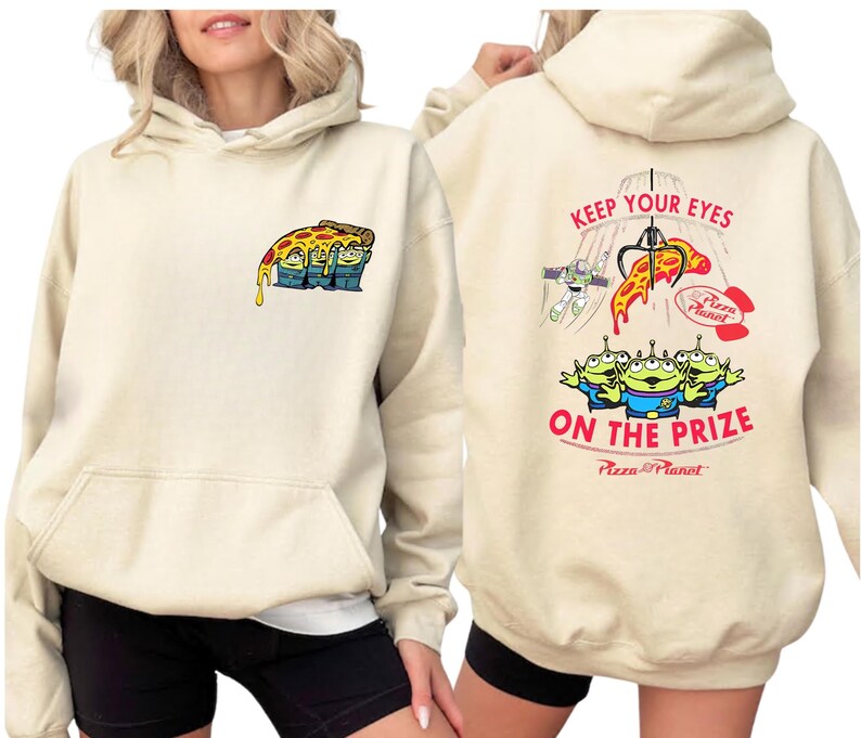 A woman wearing a beige hoodie with a colorful graphic design on the front and back.