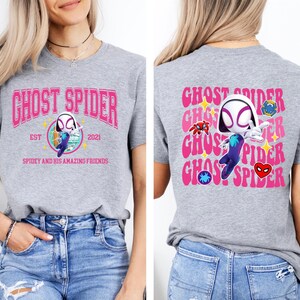 a woman wearing a grey t-shirt with a graphic design of a character from the Spider-Man franchise.