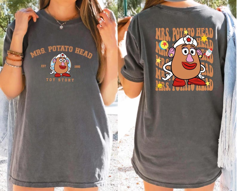 a woman wearing a gray t-shirt with a design of a cartoon character resembling Mrs. Potato Head from the Toy Story franchise.