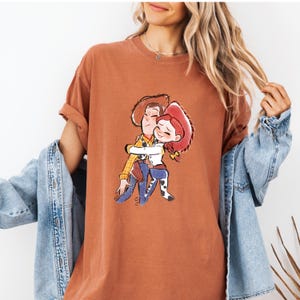 a woman wearing a t - shirt with a picture of a man hugging a woman