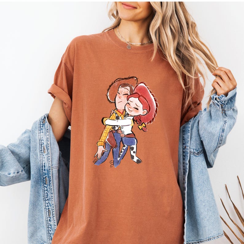 a woman wearing a t - shirt with a picture of a man hugging a woman