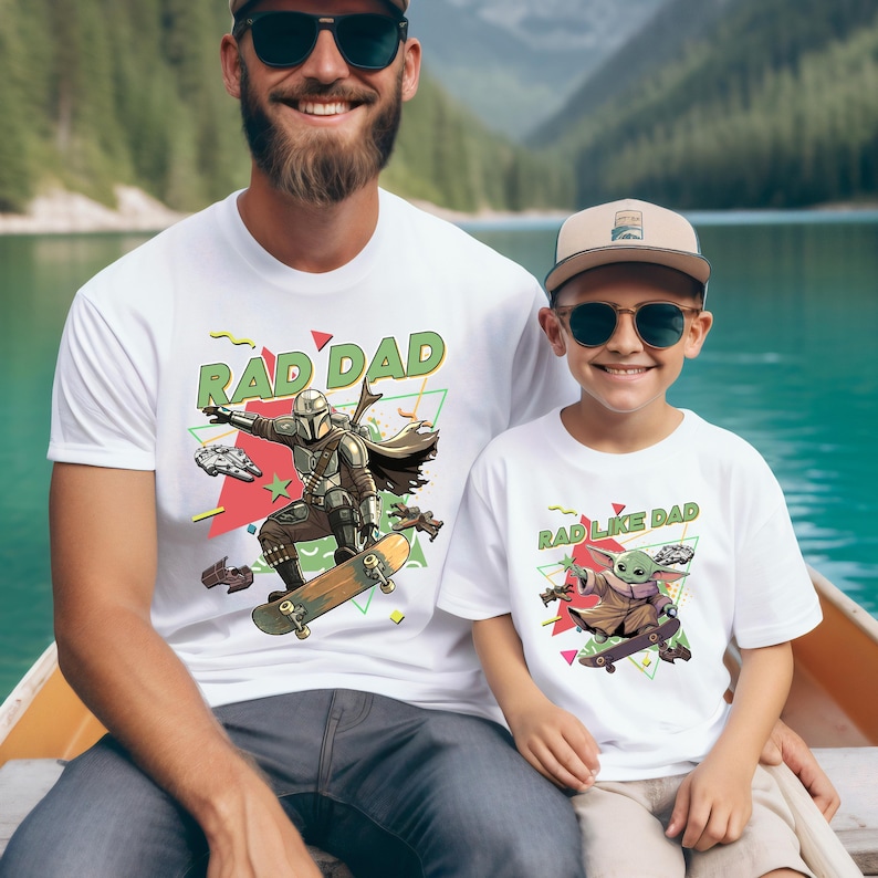 A man and a young boy wearing matching t-shirts with a graphic design featuring a character from the Star Wars franchise.
