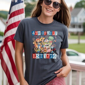 A woman wearing a t-shirt with a graphic design celebrating the 4th of July, featuring cartoon characters and fireworks.