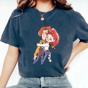 a woman wearing a t - shirt with a picture of a boy hugging a girl