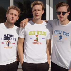 Three young men wearing white t-shirts with colorful designs and text, standing together.