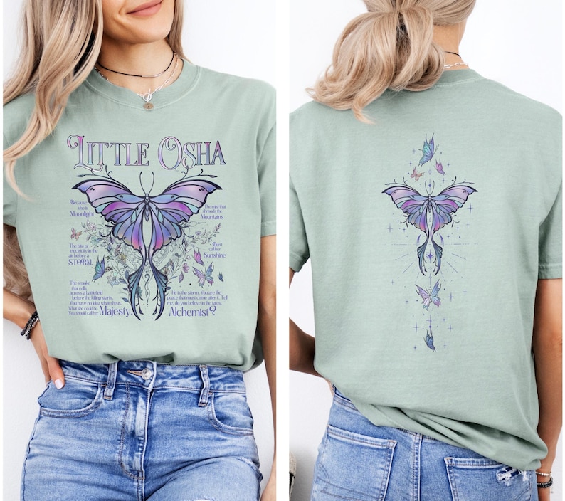 A woman wearing a green t-shirt with a butterfly design and text printed on it.