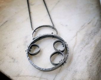 Oxidized silver modern pinned circle pendant