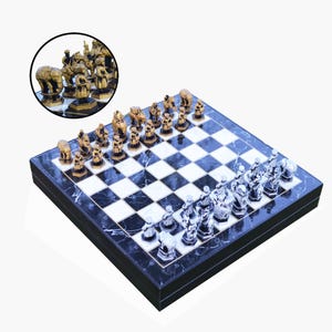 May include: A black and white marble chessboard with gold and silver chess pieces. The chessboard has a black border and is made of wood. The chess pieces are made of metal and have a detailed design.