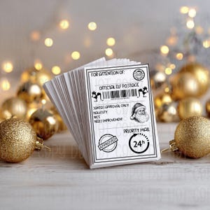May include: A pile of white rectangular cards with black text and illustrations. The cards are labelled "Official Elf Postage" and "Santa's Approval Only." An illustration of Santa Claus and a 24-hour priority mail symbol are also present.