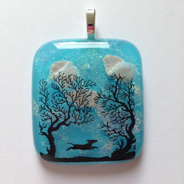 Dog Cremation Pendant where Dog is  Running in a Field of Trees and the Ashes are Seen as Clouds in the Sky