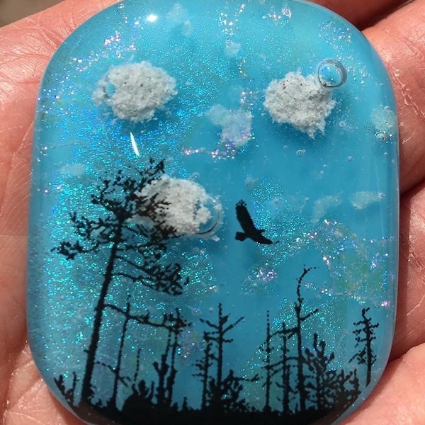 Fused glass forest cremation pendant with glow in the dark stars and ashes are seen as clouds in the sky