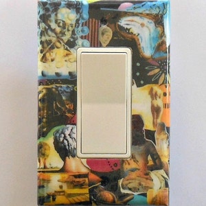 May include: A decorative light switch cover featuring a collage of surrealist art. The artwork includes images of figures, faces, and abstract shapes in a variety of colors, including blue, yellow, and red. The switch itself is white.