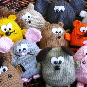 May include: A collection of handmade knitted animal toys, including a lion, elephant, bear, mouse, dog, and pig. Each toy features large googly eyes and a black nose. The toys are in various colors, such as yellow, gray, brown, orange, and pink.