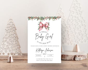 May include: A white baby shower invitation with a pink bow and green holly. The text reads "A Sweet Baby Girl is on her way". The invitation includes the name "Kathryn Johnson", the date "December 7th", and the time "2 PM".