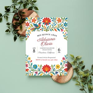 May include: A white invitation card with colorful floral and bird illustrations. The text reads "Mis Quince Años" and features the name "Adriana Olivia", date, time, and location details. Formal attire is requested.