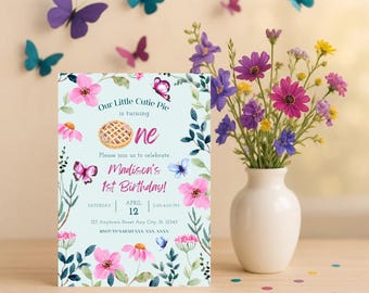 May include: A light blue invitation card with floral and butterfly accents announces Madison's 1st birthday. The card features pink flowers, a pie graphic, and the text "Our Little Cutie Pie is turning one." Butterflies of various colors decorate the background.