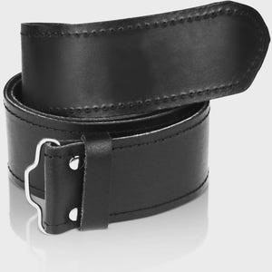 May include: A black leather belt with a silver buckle. The belt is folded in half and the buckle is visible in the center of the image.